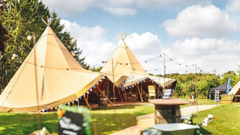Tipi venue surrounded by trees with bunting hanging