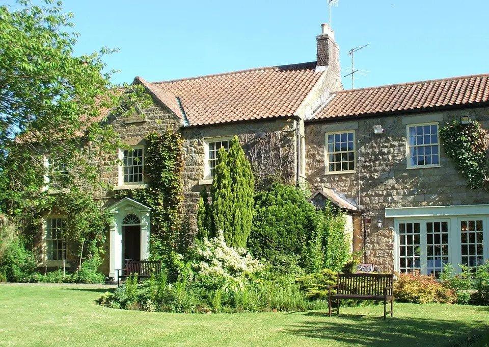 Exterior of ox pasture hall with manicured garden and climbing ivy