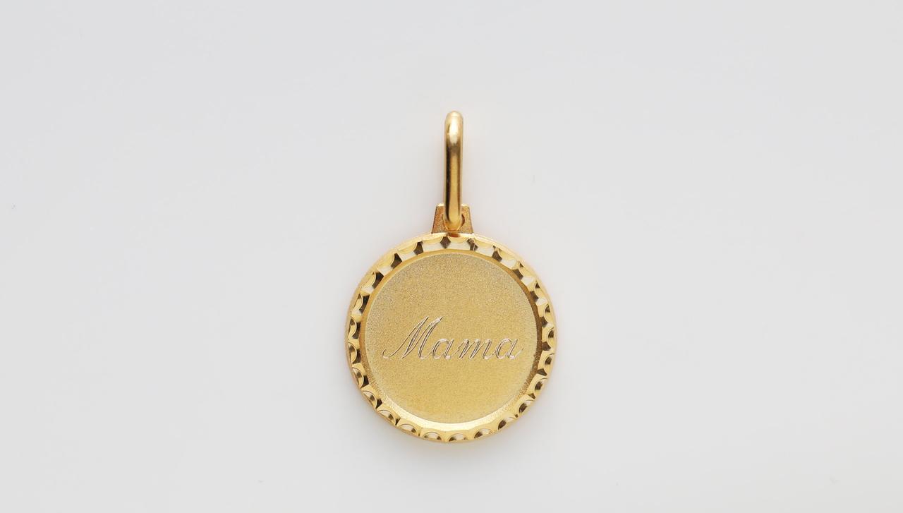 A gold diamond-cut coin featuring the word 'mama' engraved in the centre. 
