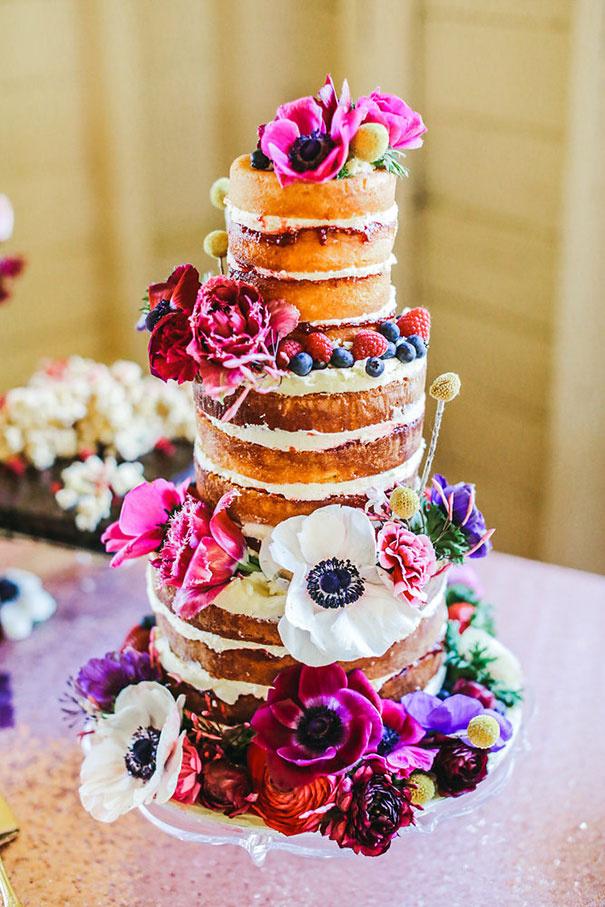 Three tiered victoria sponge rustic wedding cake with bright flowers