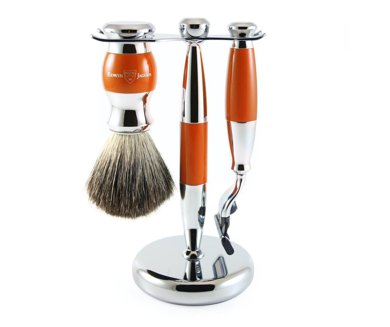 A silver and orange shaving stand with matching razor and old-school badger brush.