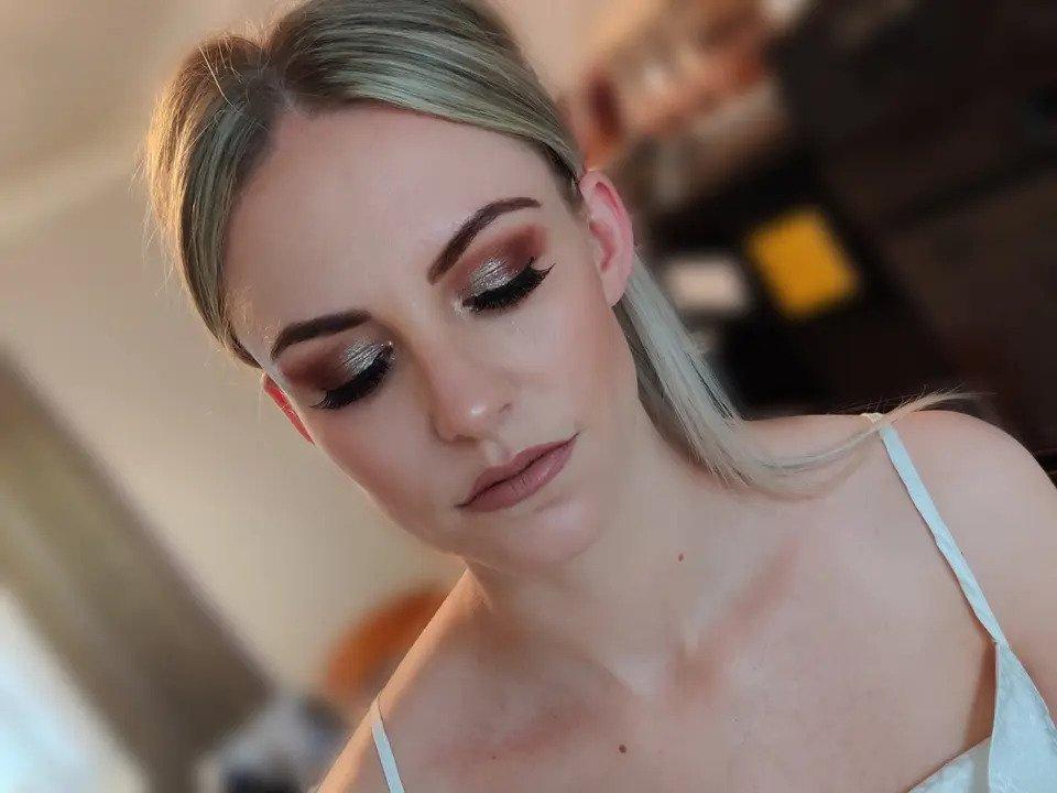 A seated bride looking down to display her eye makeup