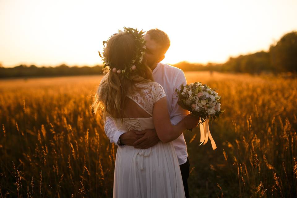 Bride and groom embracing in a field