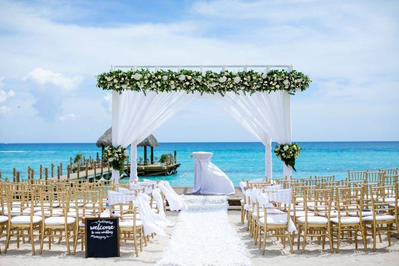 Luxury destination weddings on white sandy island, a canopy of a white bridal arch in front of a blue sea