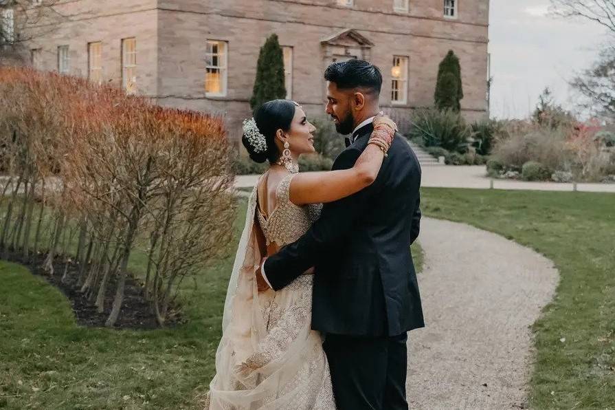 Bride and groom embracing outside of a stately home wedding venue in the North East