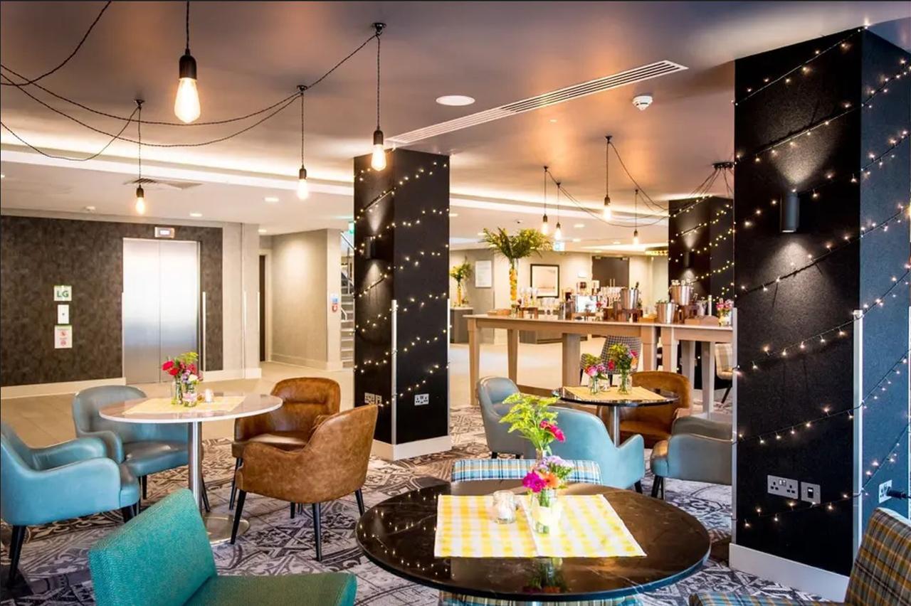 The lobby at Holiday Inn Manchester adorned with fairy lights and stylish leather and blue furniture 