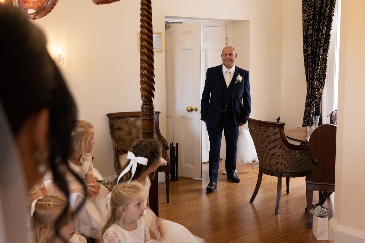 a father of the bride walks in and sees his daughter in her dress for the first time