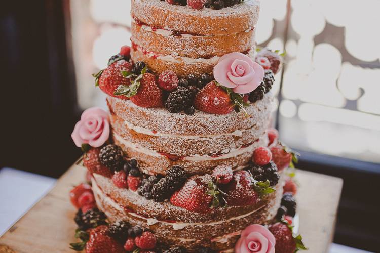 Three tiered naked victoria sponge rustic wedding cake with fruit