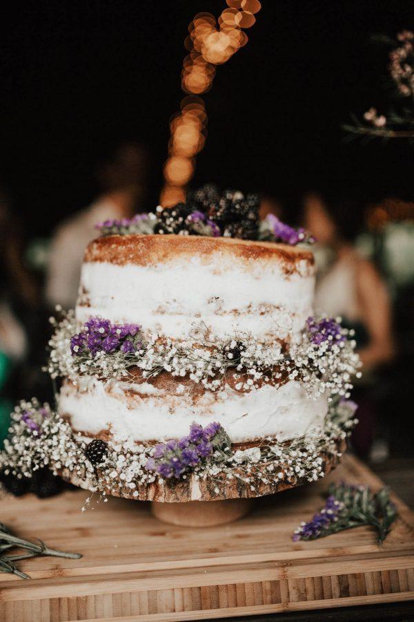 Two tiered semi naked rustic wedding cake with lavender and baby's breathe