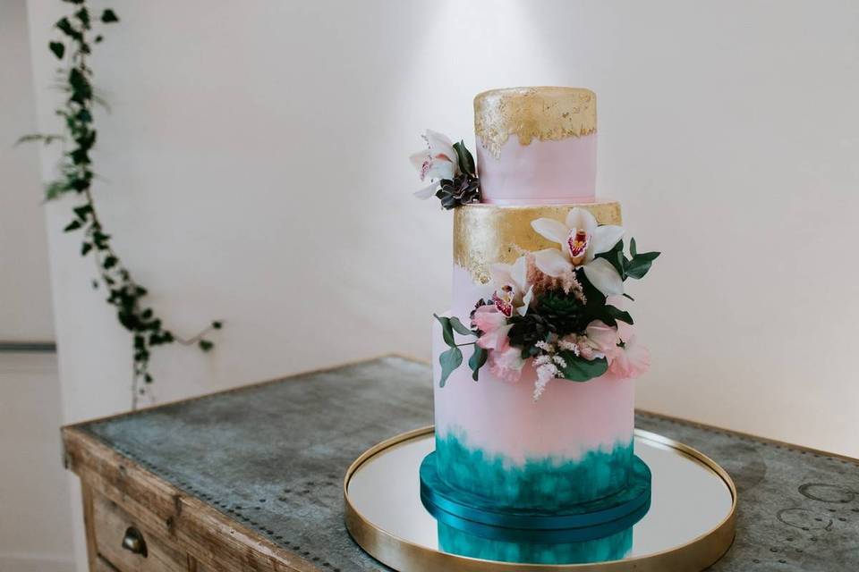 Pink gold and blue tiered wedding cake