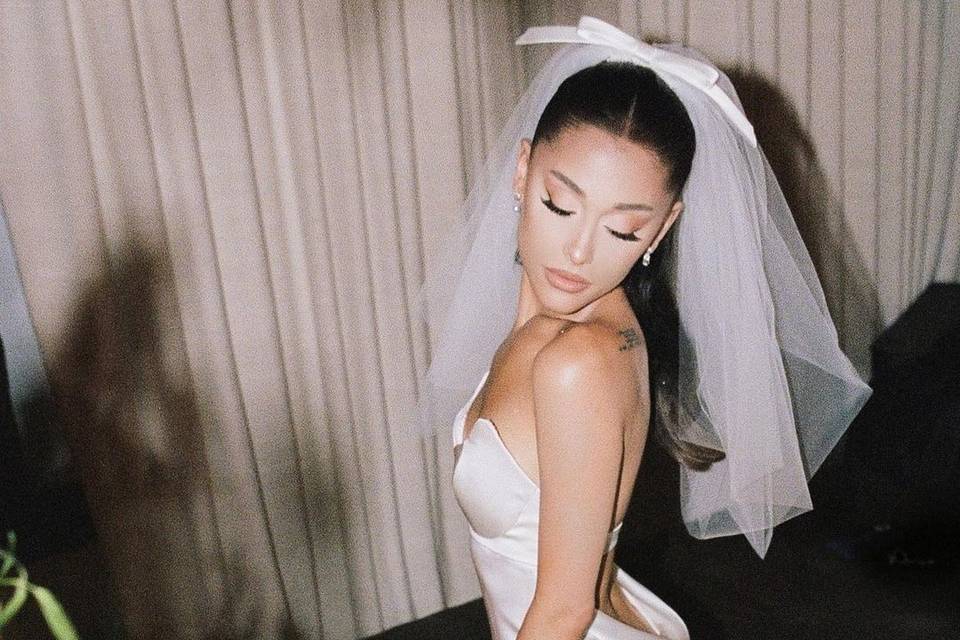 Ariana Grande posing in her iconic vera wangw edding dress looking over her shoulder