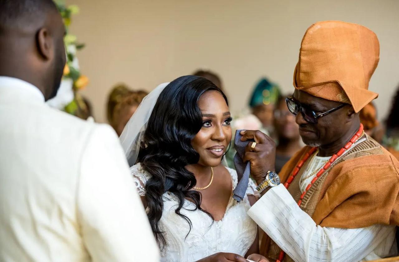 A father of the bride wiping the bride's tears away at the altar on her wedding day