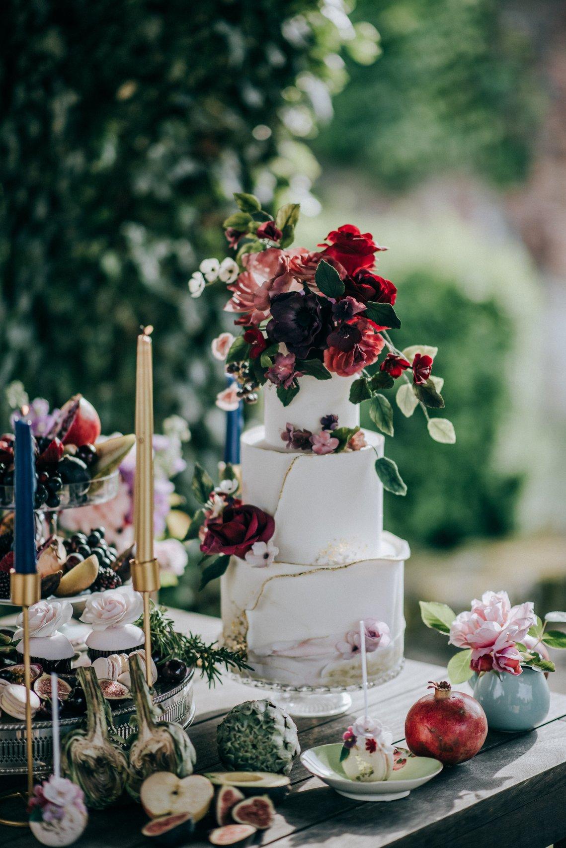 White wedding cake with burgundy sugar flowers