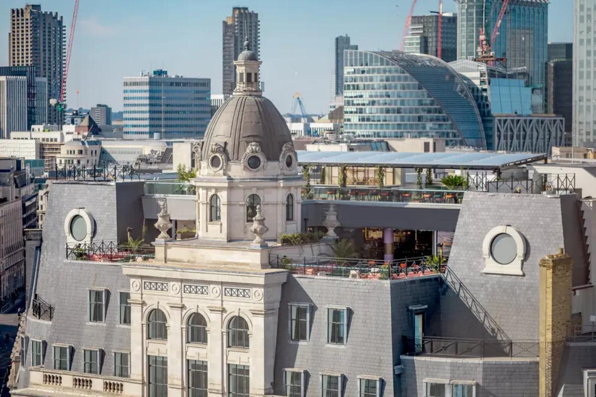  an exterior view of the balconies and bar spaces at wagtail with london skyscrapers in the background