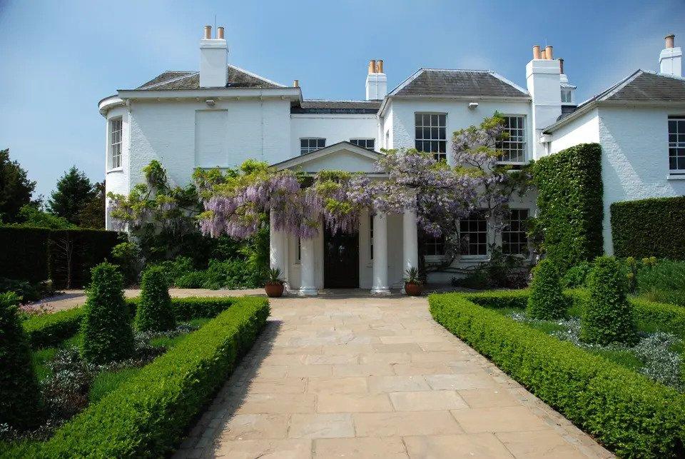 White manor house with manicured gardens