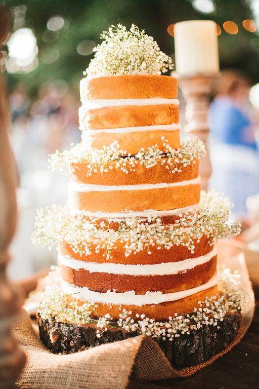 Three tiered naked rustic wedding cake with baby's breathe