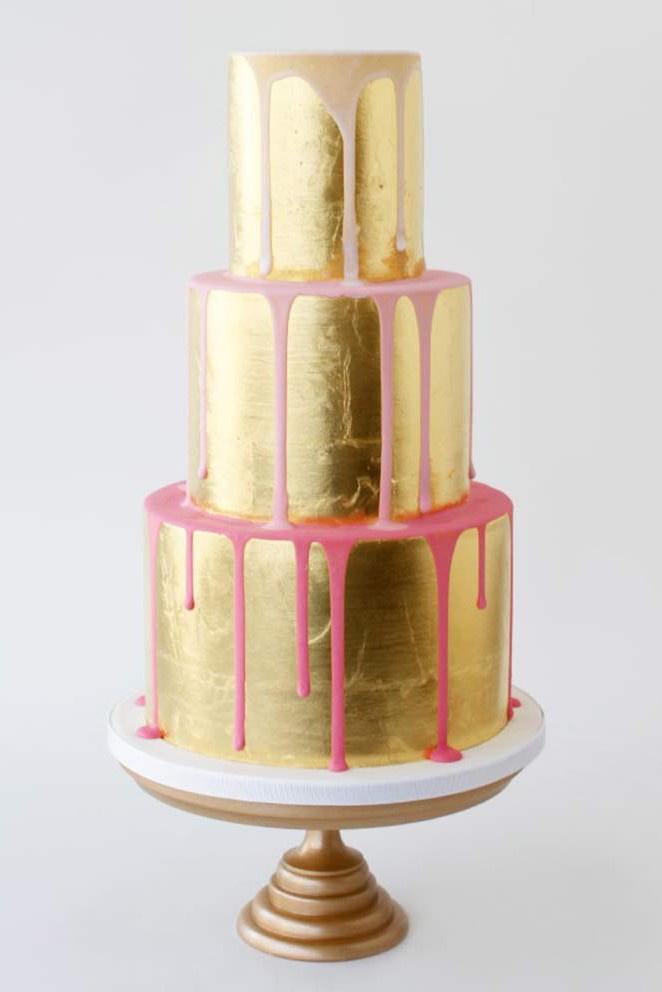 all ove gold wedding cake with ombre white and pink drip icing