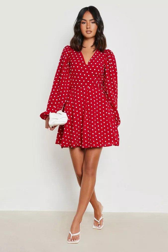 Red coloured long sleeve wrap dress with a mid-thigh hemline and a polka dot pattern