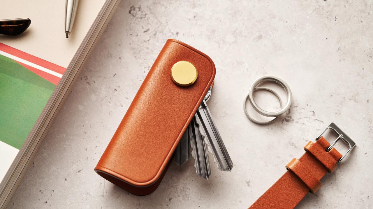 Image of a light brown leather key organiser with gold button detail, and keys poking out