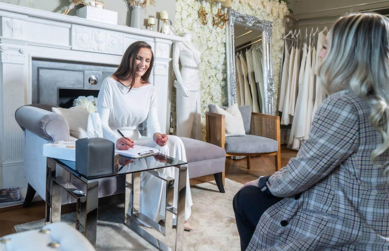 Founder and designer Rene K in consultation with a bride at her wedding dress showroom