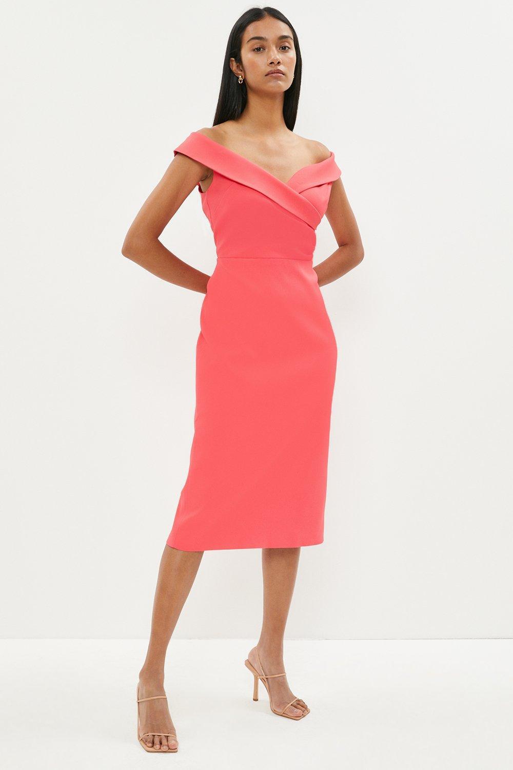 Model wearing a coral off the shoulder pencil dress