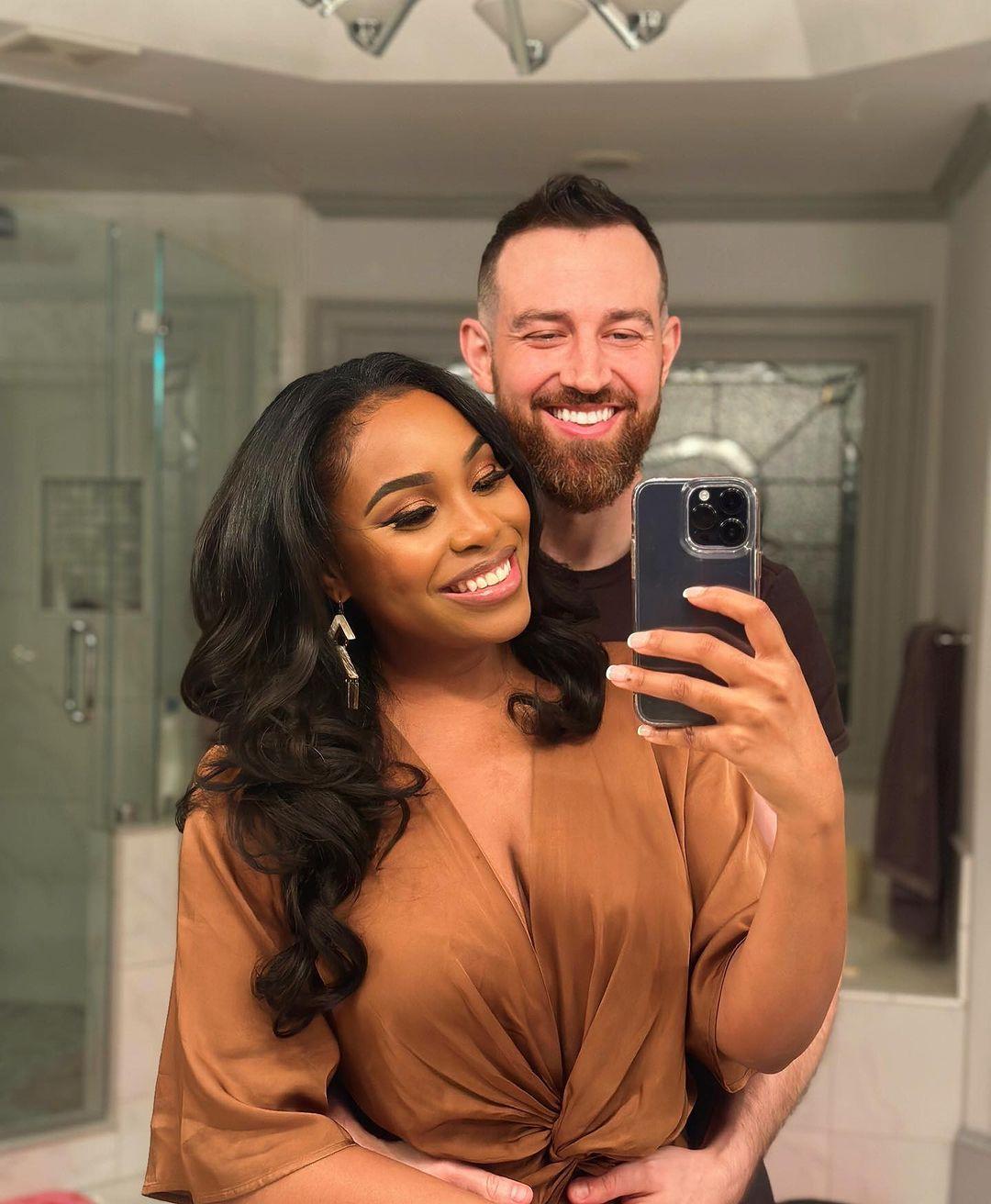 love is blind couple cameron and lauren smile and take a mirror selfie with an iphone