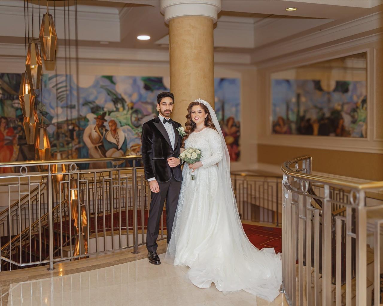 bride and groom smiling together in front of a painted wall in the Hilton London hotel