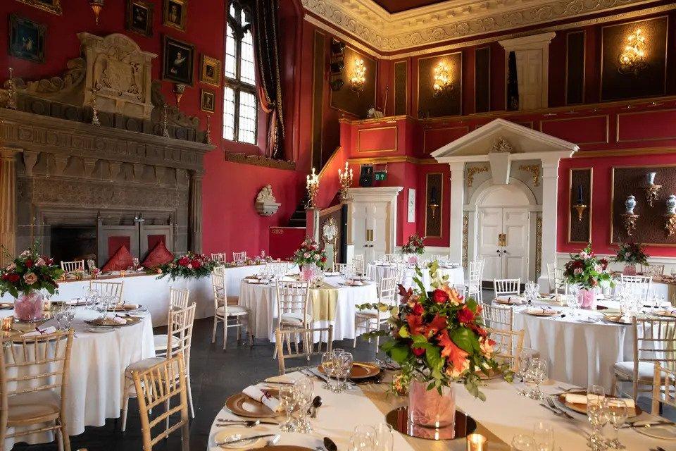 The red dining room of Lumley Castle set up for a wedding breakfast