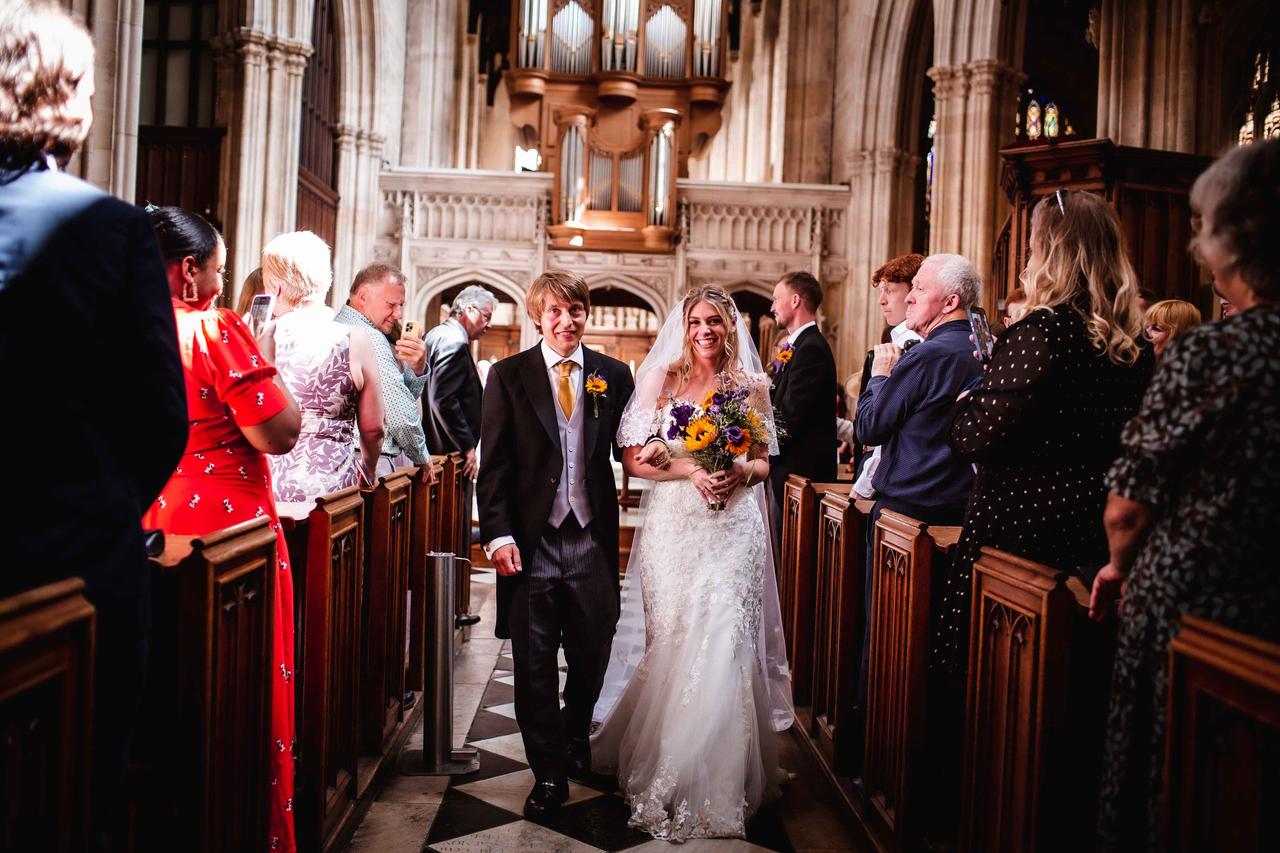 A bride and groom walk down the aisle