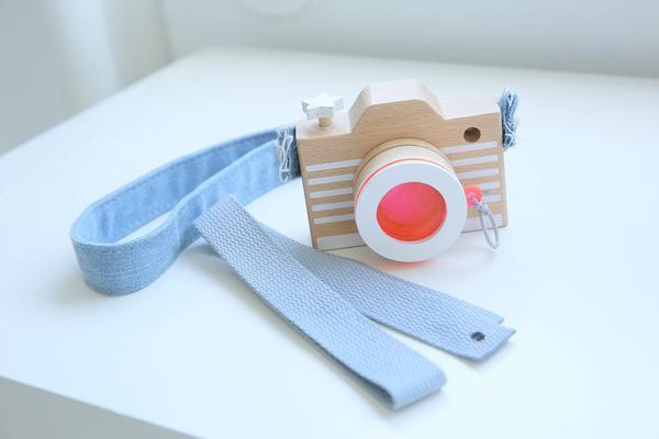 Wooden camera with a kaleidoscope lens and light blue strap