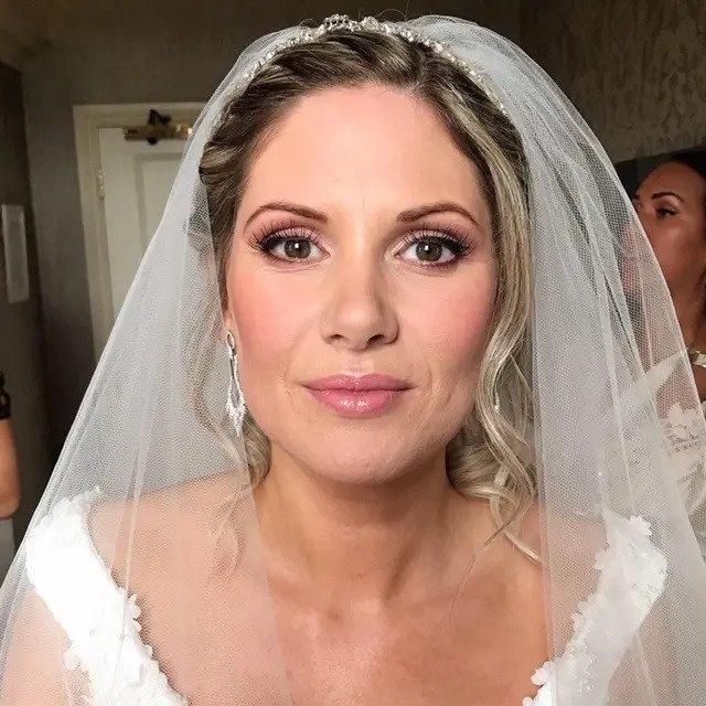 Bride wearing a veil showing her natural looking wedding makeup, complete with subtle lash extensions and warm blusher