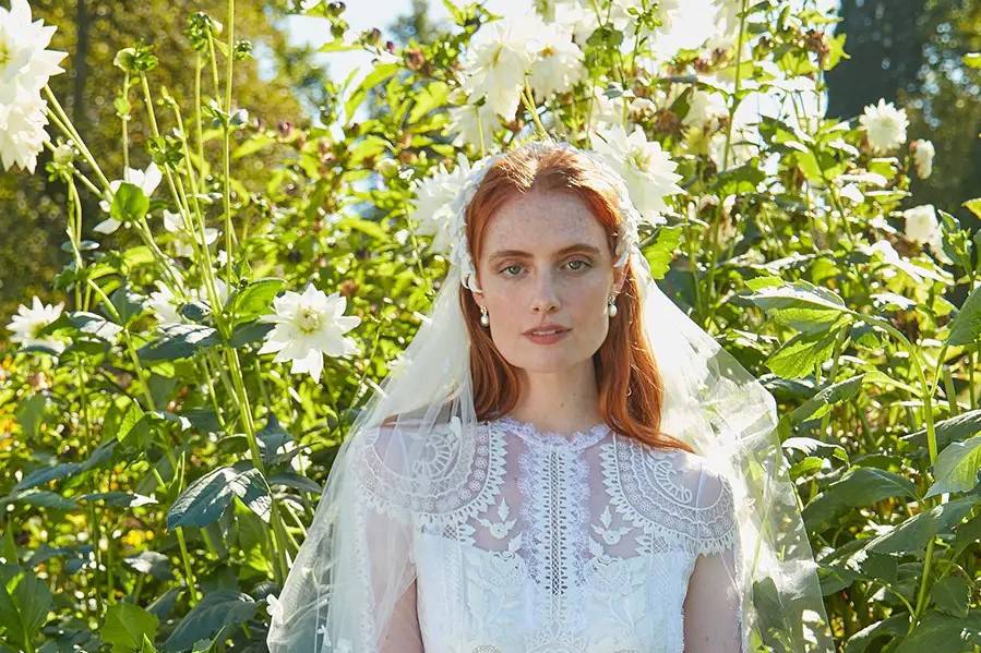 Model wearing a lace garden wedding dress with a veil 