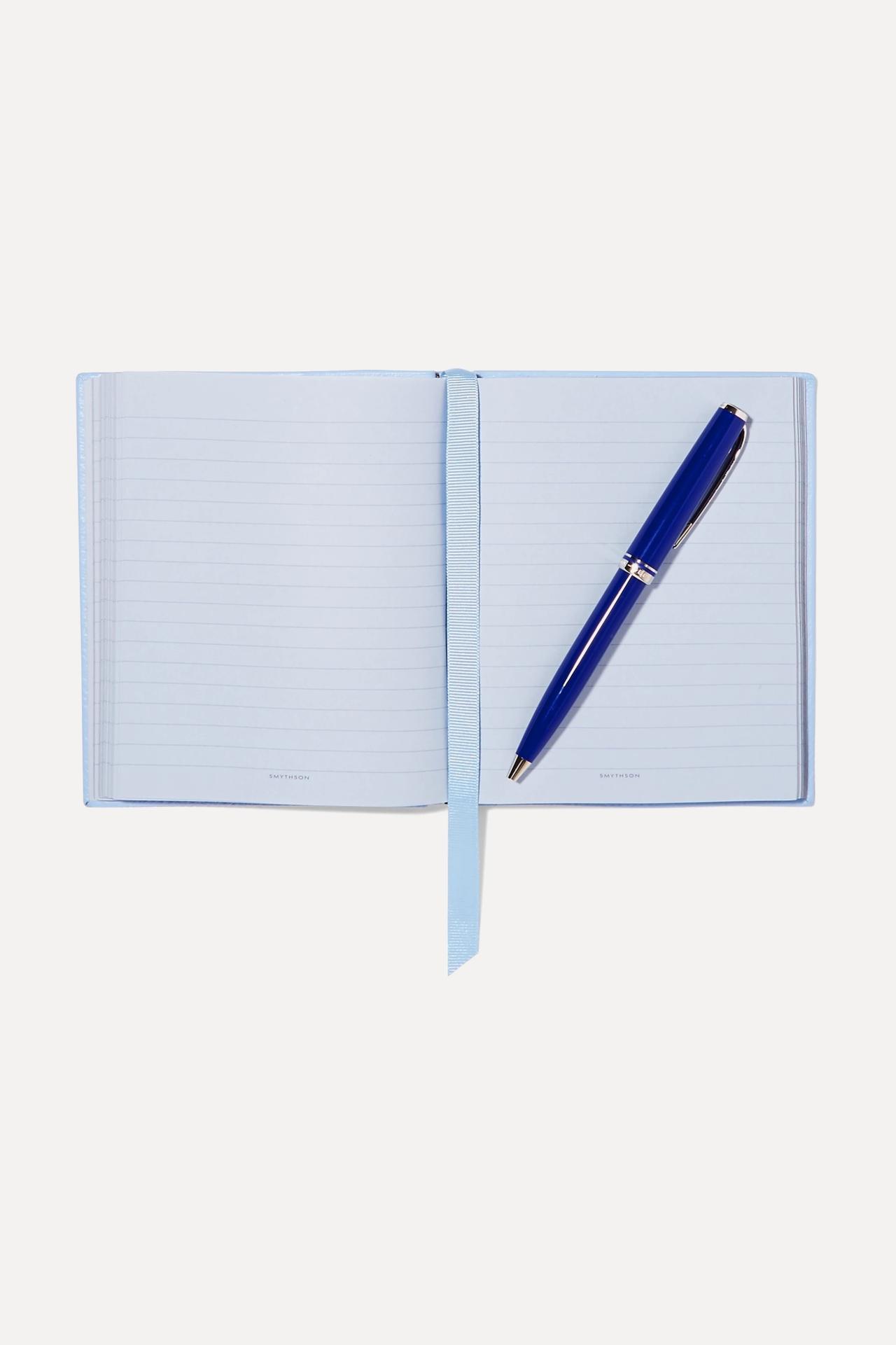 Light blue lined notebook with a royal blue pen on the right hand page