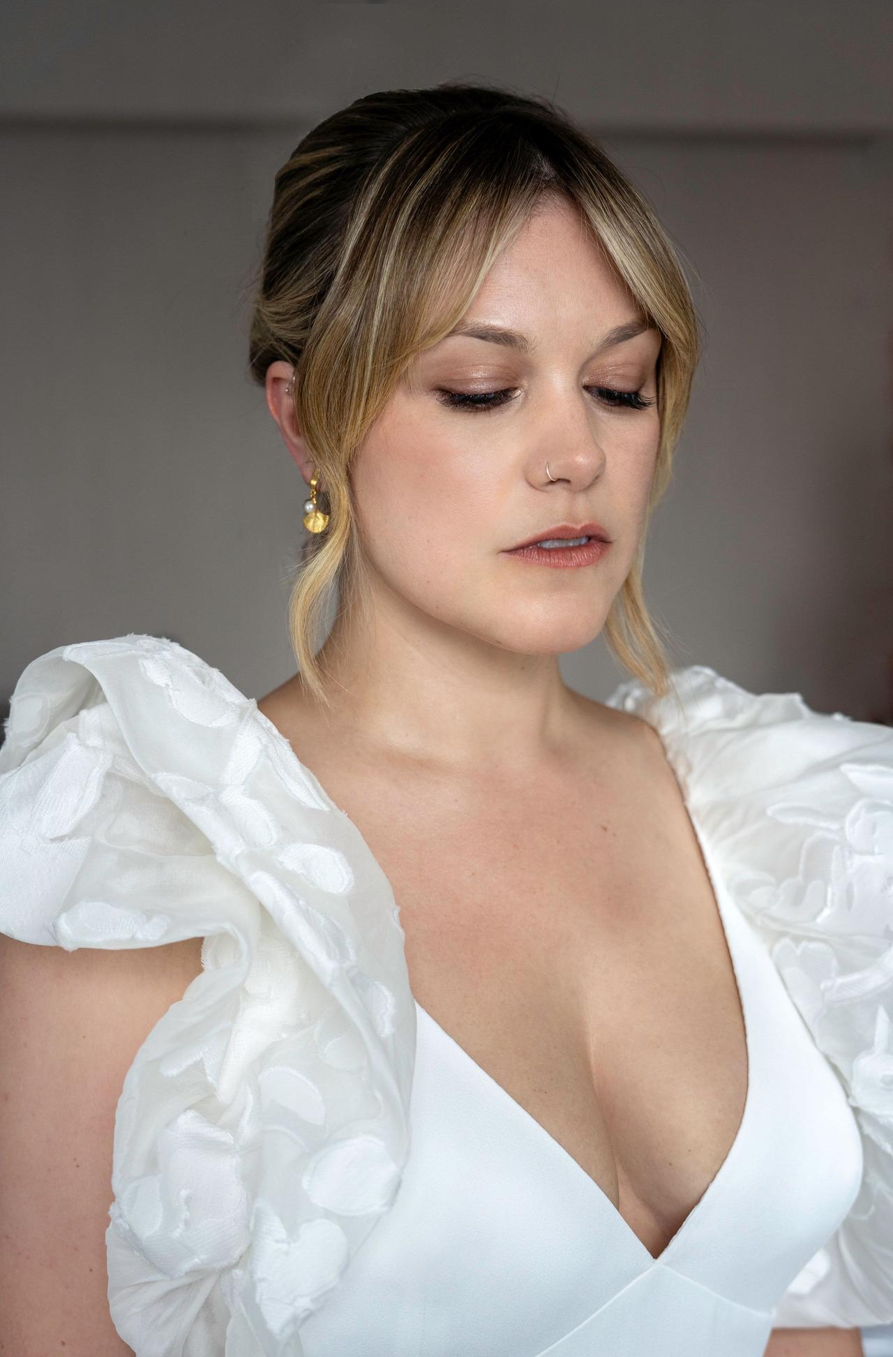 A bride wearing a white gown with floral sleeves