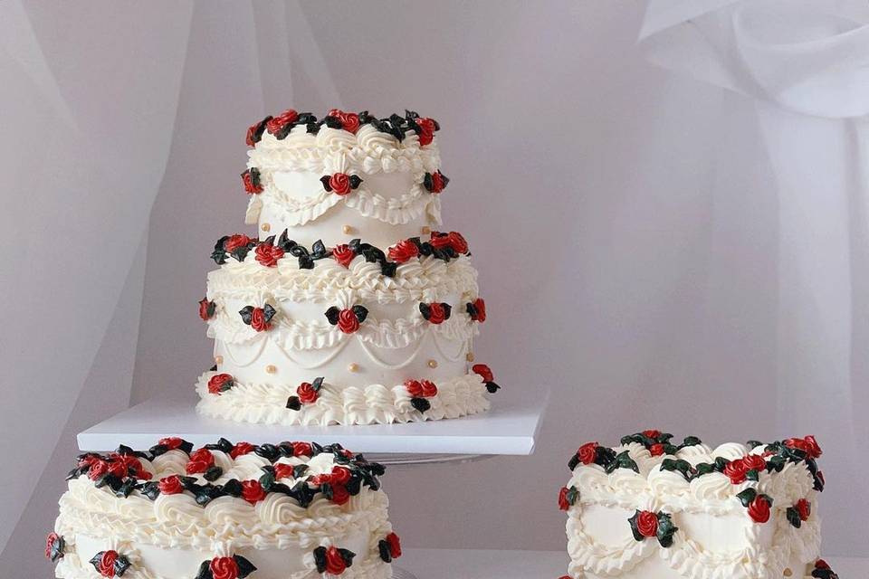 Three white cakes with red rosebuds