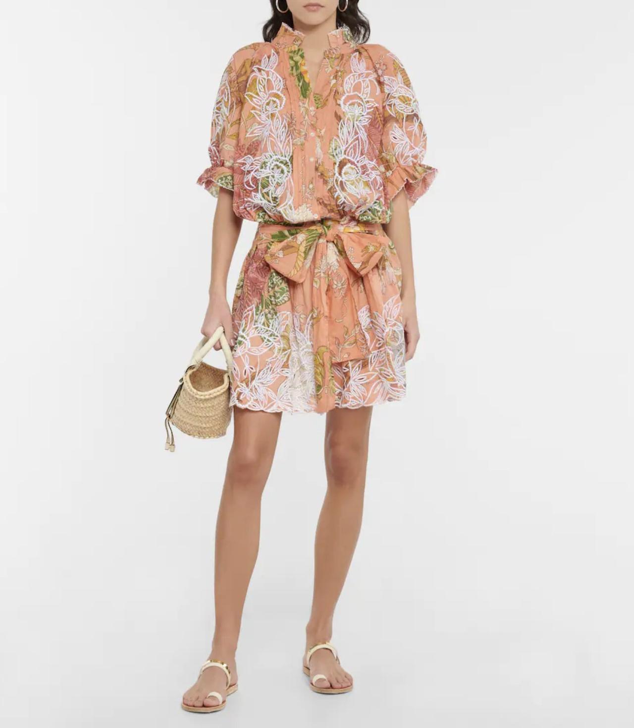 Image of a model wearing a mini dress made from lightweight cotton with that's embroidered with a floral and pintuck detailing