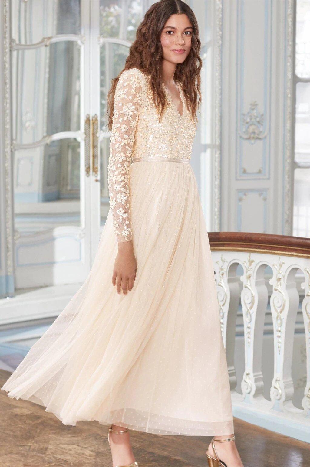 Model wearing a long sleeved sequin wedding dress