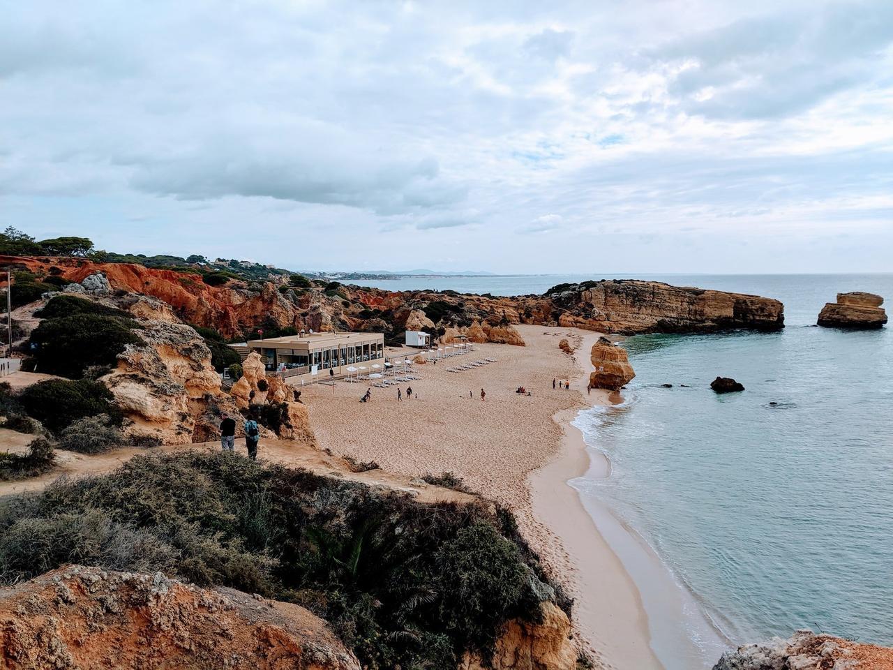 white sandy beach with the tide goin out and rocks in Portugal