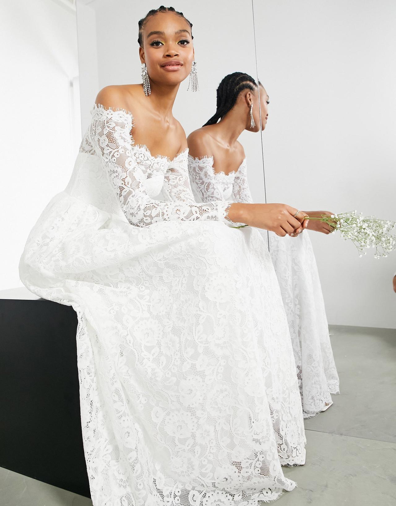 Model wearing an off the shoulder lace wedding dress