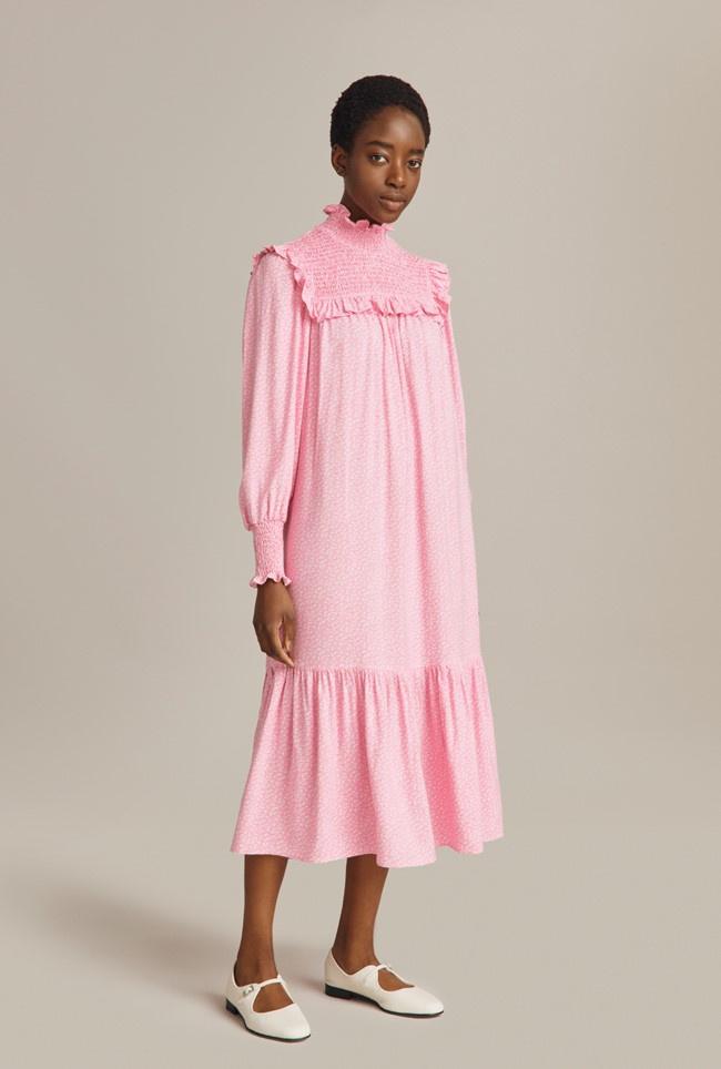 Model wearing a pink collared wedding guest dress