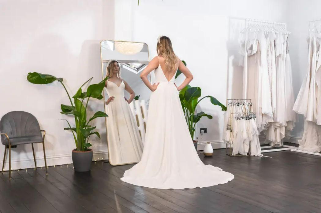 Bride trying on a simple wedding dress in a wedding boutique