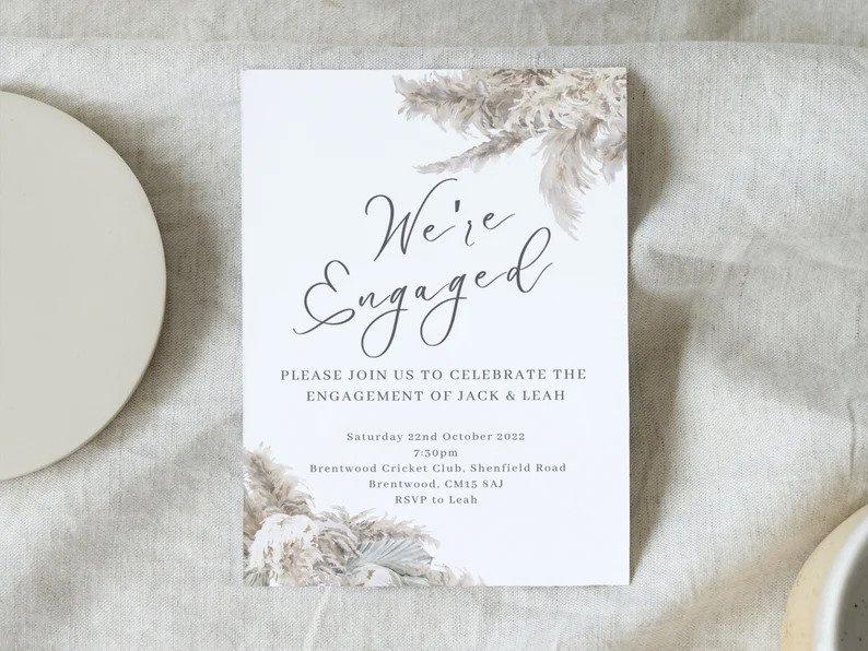 White engagement invitation with cream foliage detailing