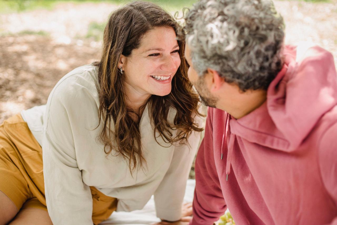 couple in a park smiling at each other