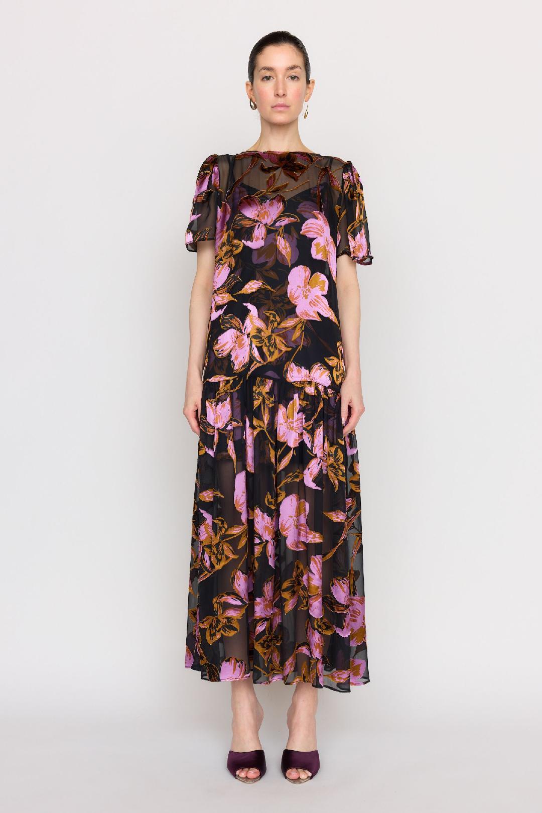 A wedding guest wearing an oversized floral print midi dress with short puff sleeves and a drop waist.