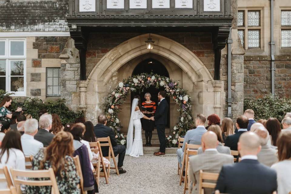 An outdoor ceremony in front of a large mansion