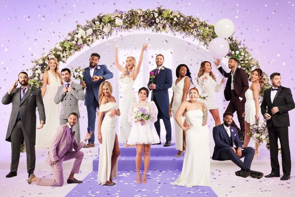 the married at first sight uk 2023 cast members in wedding attire posing against a lilac background with a floral arch