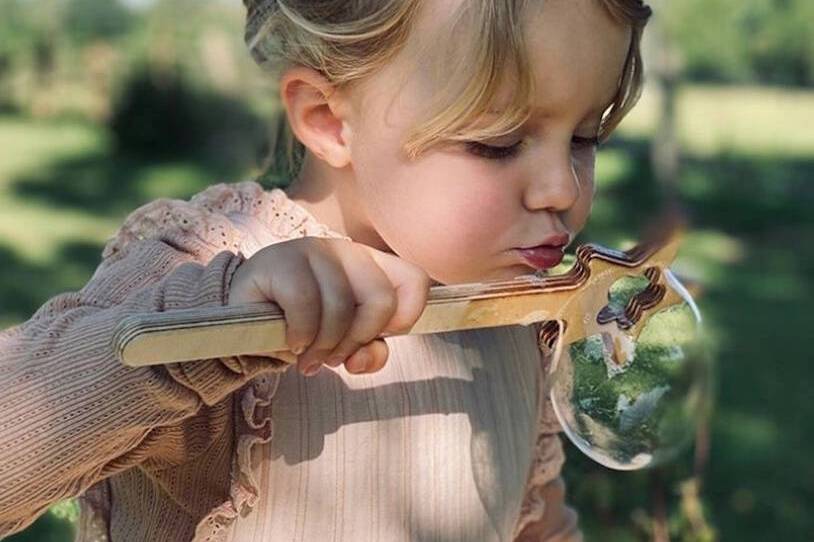 Young girl blowing bubbles from a bubble wand