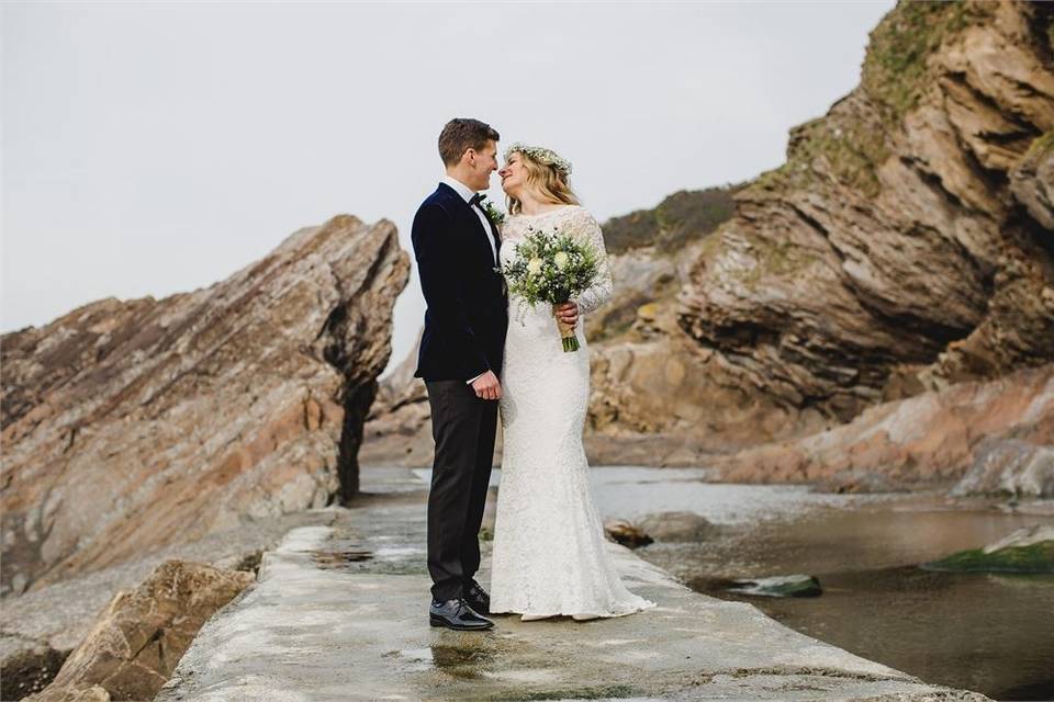 Bride and groom standing at the coast