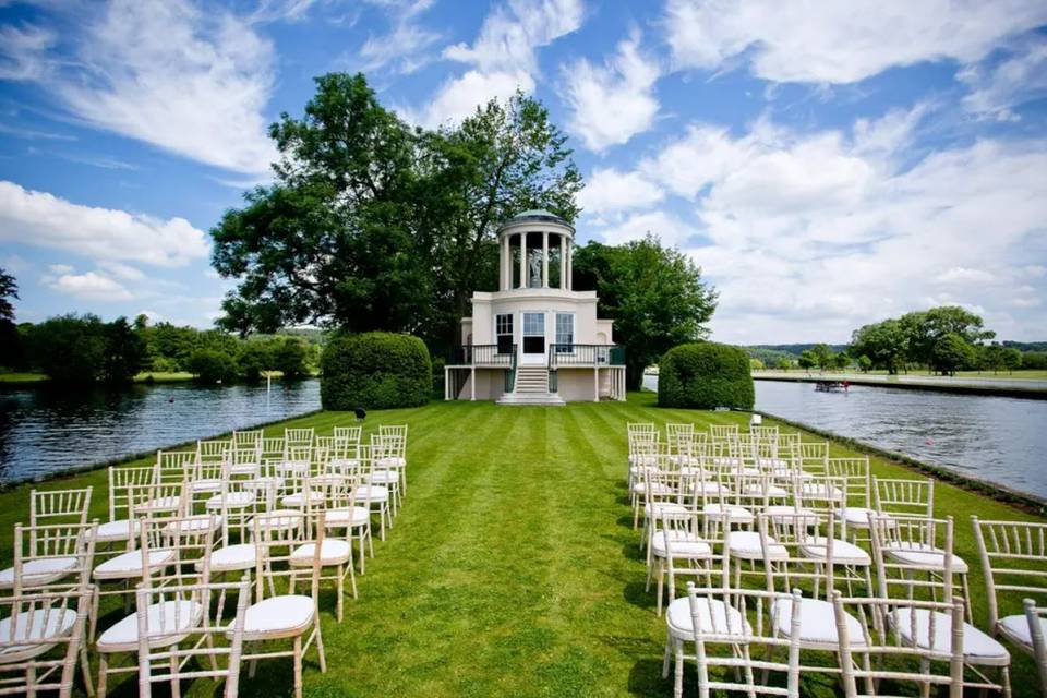 A ceremony set up on the grass at Temple Island surrounded by water