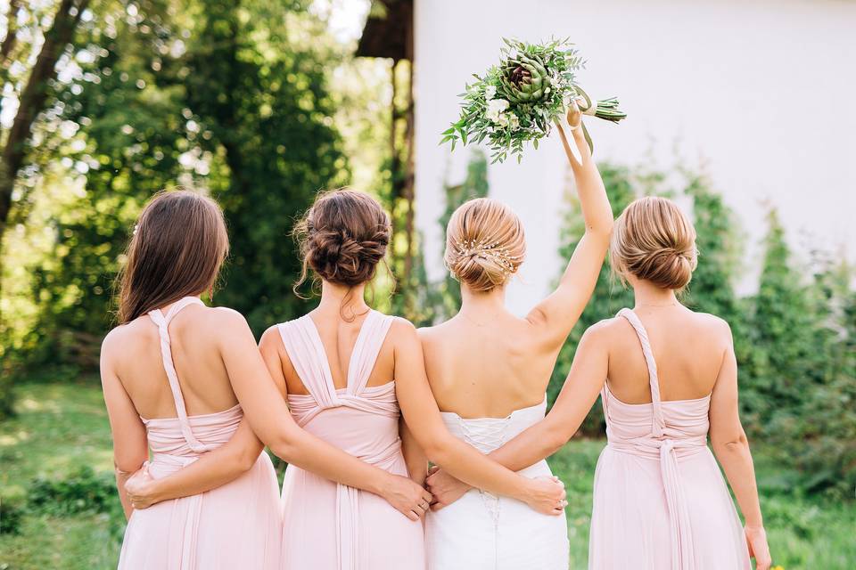 Bride and three bridesmaids in pink, shot from behind